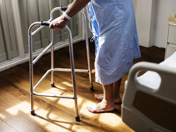 Patientin mit Gehgestell nach einer Operation